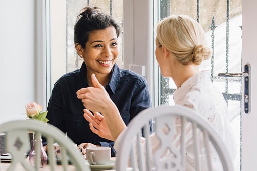 voice-disorders-evaluation two women engaging in conversation and sharing breakfast together
